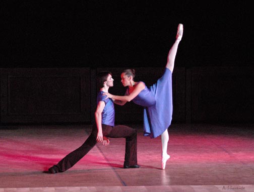 Two ballet dancer pose on on one knee while the other doing an arabesque.