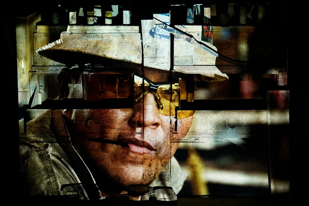 Image of a worker wearing hardhat being projected onto the industrial structures of Donovan Mill. Part of a Breaking Ground, an immersive exhibit by Valery Lyman.
