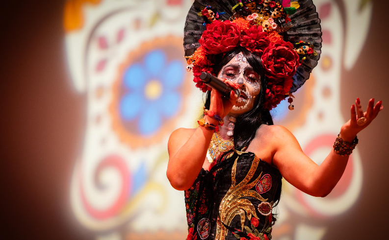 Singer in calavera makeup performs.