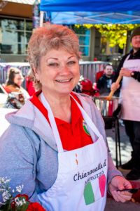 An image of a person with a chef's apron on smiling at the camera