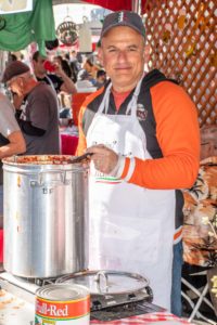 An image of another person stirring a big pot of sauce