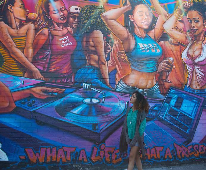 three young women stand together holding awards and smiling in front of a microphone showcasing their accomplishments