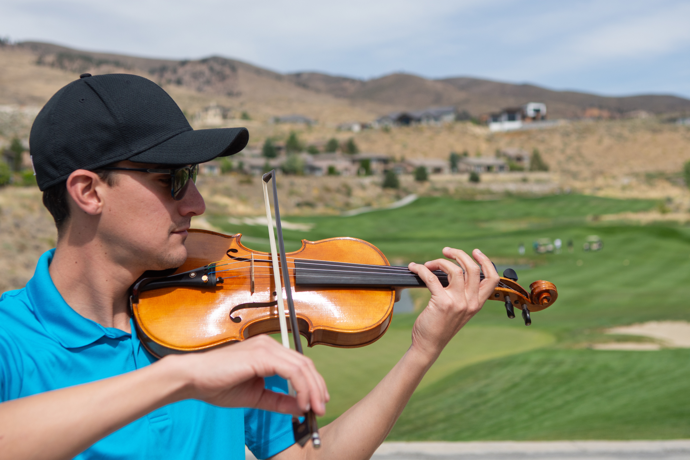 A violinist play on a golf course