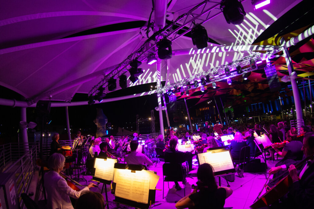 Musicians at the Pops on the River event under purple lighting