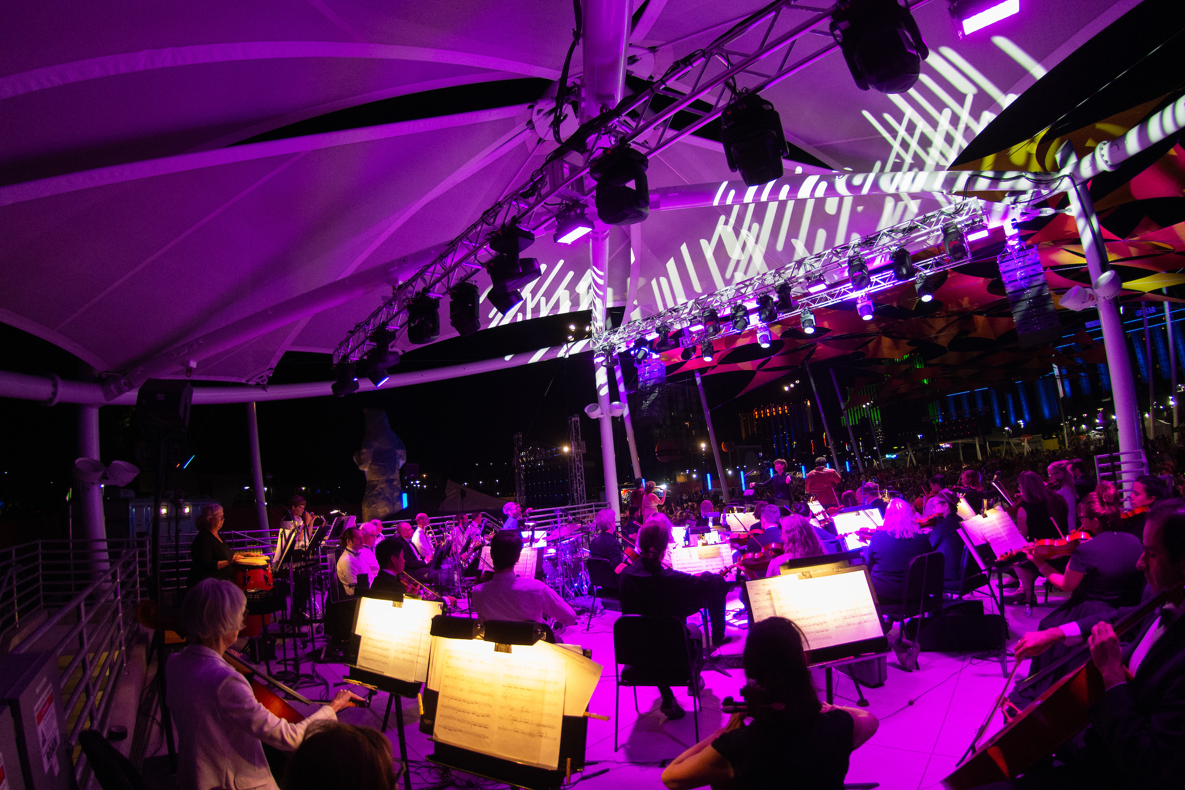 Musicians at the Pops on the River event under purple lighting