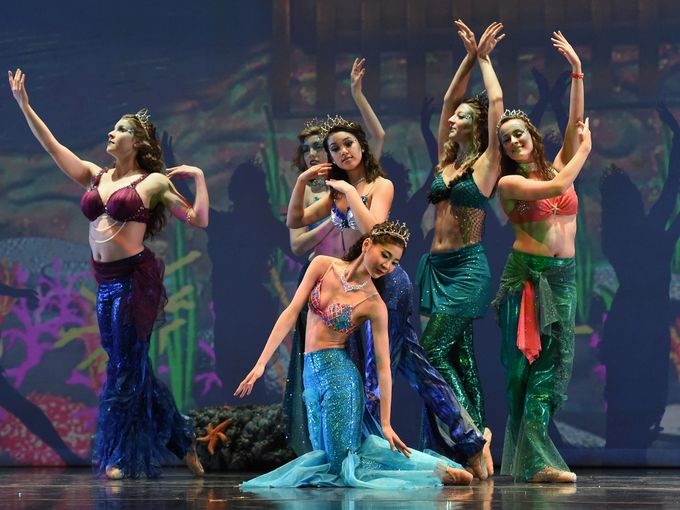 Performers dresses as mermaids dance.