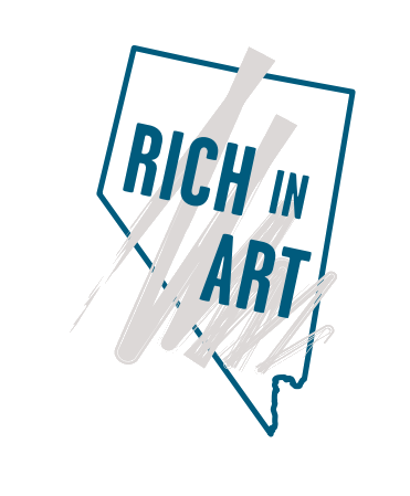 Outline of Nevada with the words “Rich in Art” in bold blue letters, overlaid by abstract gray paint strokes.